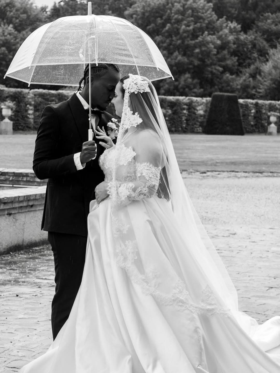 Emma et Olivier sous un parapluie dans le parc du Château de Breteuil